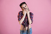 Beautiful fashionable woman with braids covers her mouth with her hands