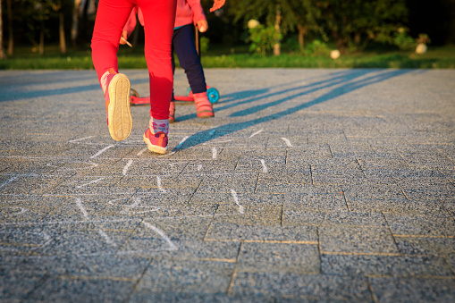 little girls play hopscotch on playground, kids have fun outdoors