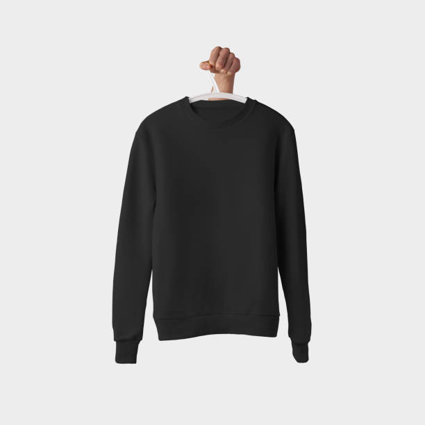istock Presentation of a blank black sweatshirt hanging on a white hanger with a hand for advertising in an online store. 1221548493
