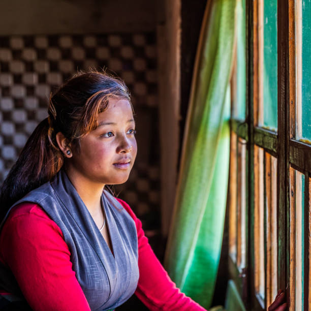 istock Tibetan young woman looking through the window, Upper Mustang, Nepal 1221550794
