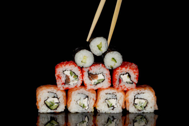 istock Philadelphia roll with salmon, cheese and cucumber on a black background with reflection. Sushi Philadelphia 1221552229