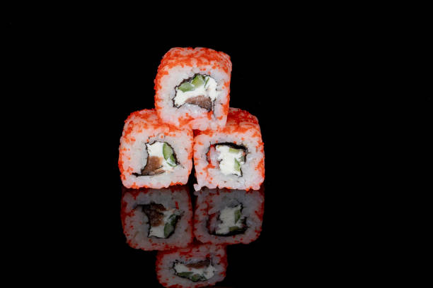 istock Philadelphia roll with salmon, cheese and cucumber on a black background with reflection. Sushi Philadelphia 1221552232