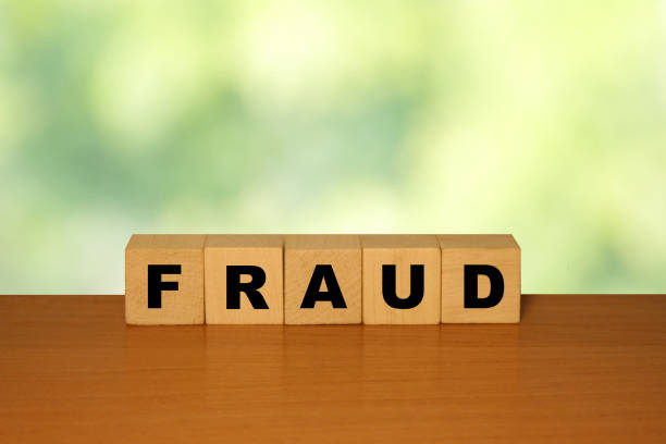istock FRAUD message word on a wooden desk on cube blocks with a green nature background 1221552383