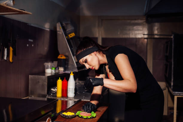 istock beautiful girl Cook prepares the kitchen Burger 1221552633