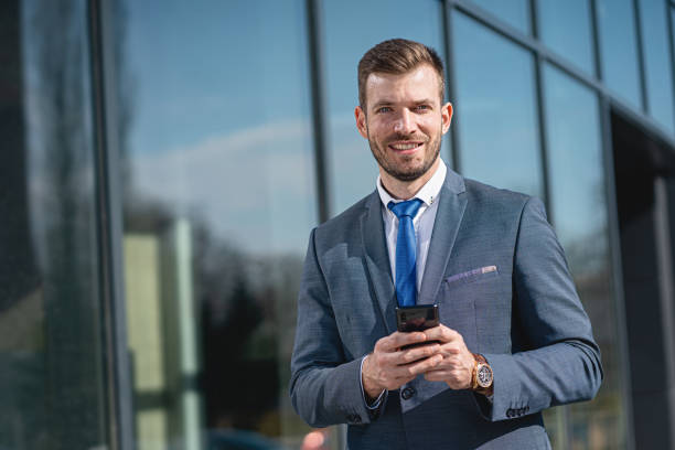 istock Smiling businessman using cellphone on the way to work 1221553911