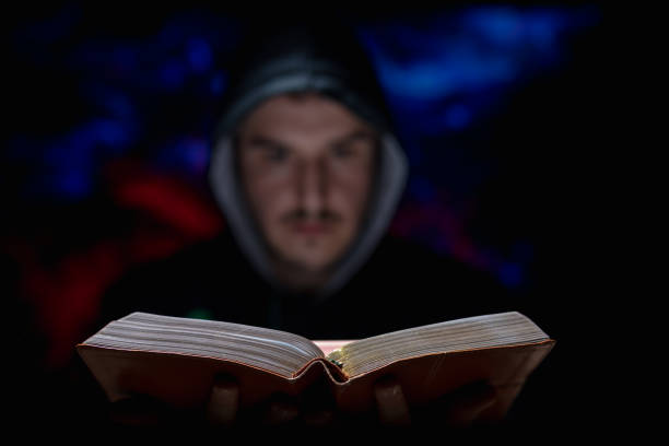 istock Blurred man on dark background holding a book in his hands religious concept 1221553916