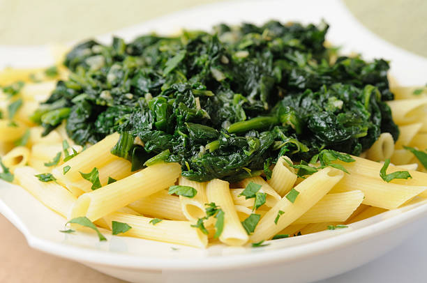 An up close picture of pasta with spinach on it Past with plenty of spinach on the top spinach pasta stock pictures, royalty-free photos & images