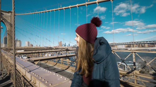 istock Young beautiful woman relaxes on Brooklyn Bridge while enjoying the amazing view 1221562019
