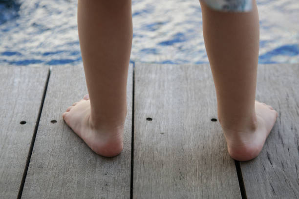Barefoot toddlers feet standing on the wooden floor Barefoot toddlers feet standing on the wooden floor pes planus stock pictures, royalty-free photos & images