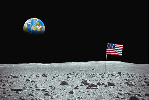 Flag of the USA on the moon with planet Earth on the sky. Photomontage, photo of the Earth has been used thanks to the NASA archive.\nhttps://www.nasa.gov/content/satellite-view-of-the-americas-on-earth-day