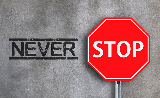 Never stop with stop sign on wall background.