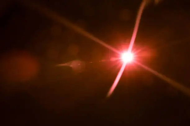 Photo of abstract lens flare red light over black