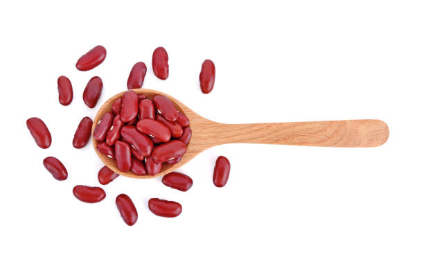 istock Red beans on wooden spoon isolated white 1221566468