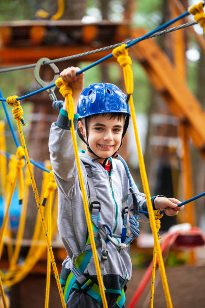 istock Young boy climbing pass obstacles in rope. Child in forest adventure park. 1221567435