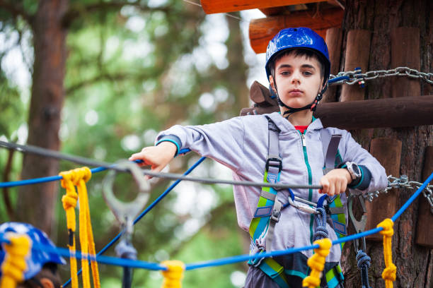 istock Young boy climbing pass obstacles in rope. Child in forest adventure park. 1221567437