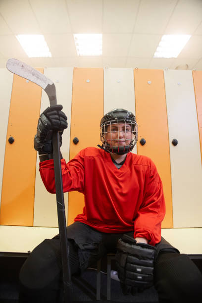 istock Female Hockey Player Posing in Locker Room 1221570570