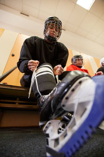 istock Female Hockey Player Putting on Skates 1221570577
