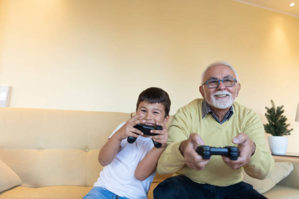 istock Handsome Grandpa and Grandson are Playing Game Console While Spending Time Together at Home. 1221572170
