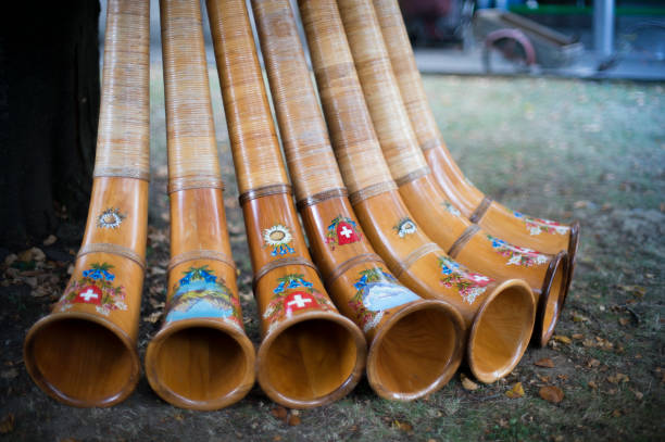 Alphorn_AlphörnermitWappen_Volksfest Assembly of alphorns with Swiss coat of arms alpenhorn stock pictures, royalty-free photos & images