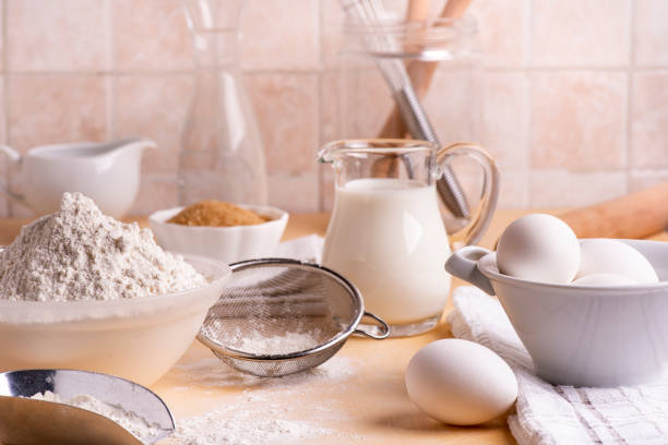 in the kitchen on the table some utensils, flour, milk and eggs and various ingredients ready for the preparation of homemade culinary recipes
