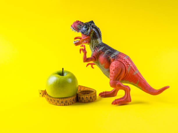 istock Green apple with measuring tape and dinosaur 1221578062