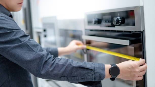 istock Asian man using tape measure on oven 1221578888