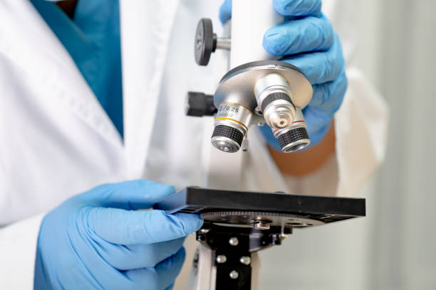 istock Asian scientist biochemist or microbiologist working research with a microscope in laboratory. For protect outbreak Coronavirus Covid19, bacteria and germs. 1221581158