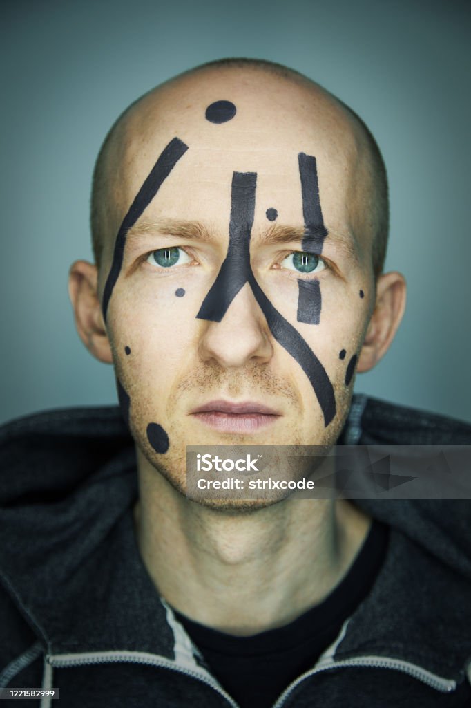 Close up portrait of man hiding his face from camera recognition with special camouflage makeup. Digital privacy in big city concept image. Adult Stock Photo