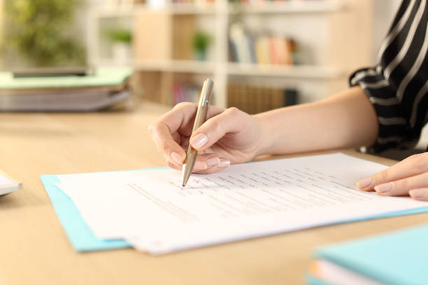 istock Woman hands filling out form working at home 1221585512