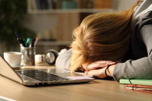 istock Tired student sleeping over desk at home in the night 1221585587