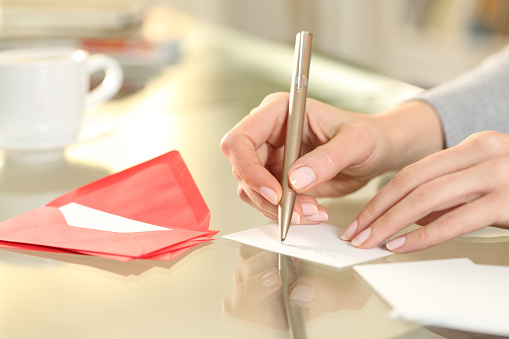 Mujer escribir a mano tarjeta de felicitación en casa photo