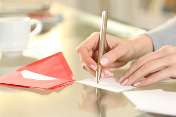 mujer escribir a mano tarjeta de felicitación en casa - message fotografías e imágenes de stock