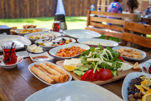istock Turkish breakfast on a wooden table which is placed in a garden - serpme kahvalti 1221586799