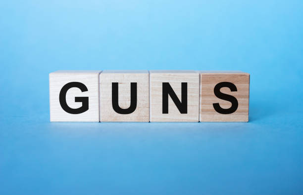 istock GUNS - cube with letters, sign with wooden cubes on blue background 1221586918