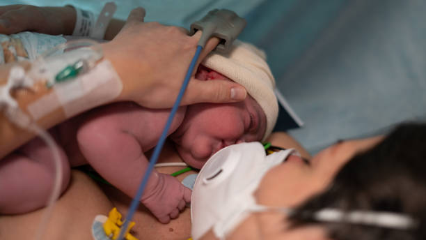 New born by caesarean section New born by caesarean section in Covid-19 and his mother with mask airtight photos stock pictures, royalty-free photos & images