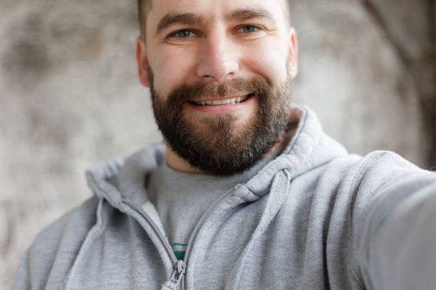 istock bearded man on a gray background makes a selfi 1221593248