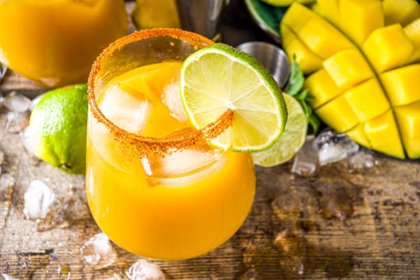 Mango daisy Summer tropic mexican cold cocktail. Mango margarita cocktail, with tequila, lime, lemon, hot chili jalapeno peppers. Wooden background with bar party utensils copy space mango fruit photos stock pictures, royalty-free photos & images