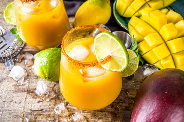 Mango daisy Summer tropic mexican cold cocktail. Mango margarita cocktail, with tequila, lime, lemon, hot chili jalapeno peppers. Wooden background with bar party utensils copy space tequila drink photos stock pictures, royalty-free photos & images
