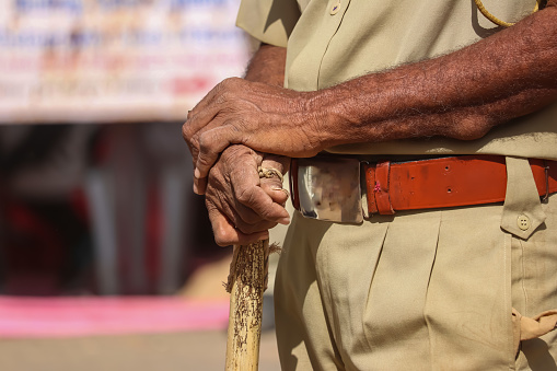 Policía indio cerca de palo de la policía y uniforme, policía indio (CRPF) con palos de bambú patrullas, enfoque selectivo, mano en mano policía vista de hombre photo