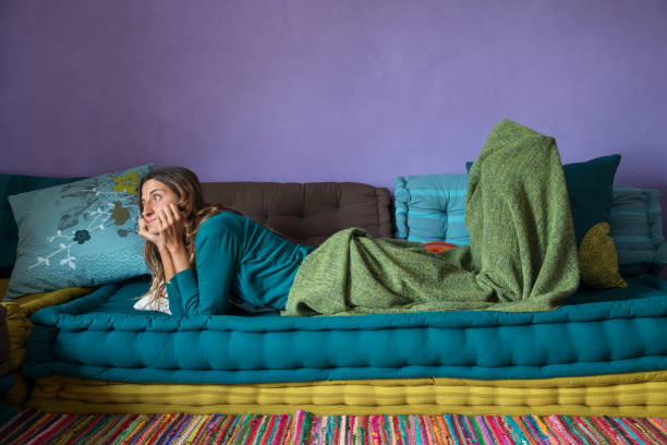 istock woman relaxing on a sofa with a blanket 1221596477