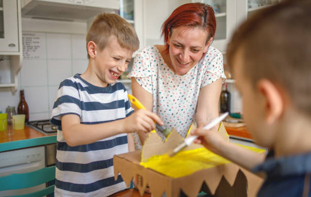 istock Mom and kids making a cardboard dinosaur costume 1221598523