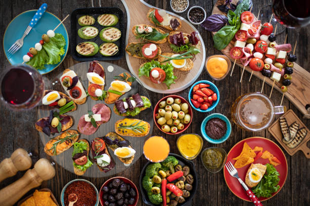 istock Many tapas on the rustic wooden table with black background. 1221598575