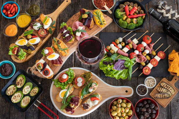 many tapas on the rustic wooden table with black background. - italian cuisine wine food pasta imagens e fotografias de stock