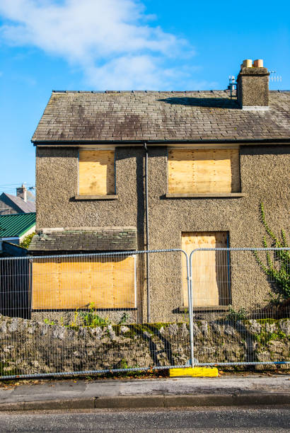 istock An abandoned house boarded up and fenced off 1221599985