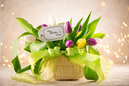 a bouquet of colorful spring flowers in a wicker basket