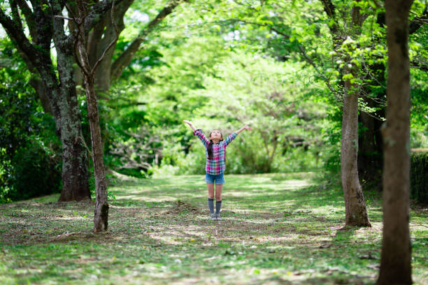 Girl with open arms in the woods