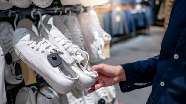 istock Customer hand choosing white sneakers in clothing store 1221602320