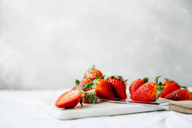Slices of fresh strawberries on chopping board