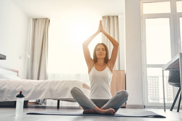 istock Relaxed young woman sitting in yoga pose 1221605648