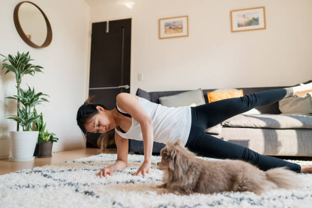 istock Woman exercising at home with her dog 1221605961